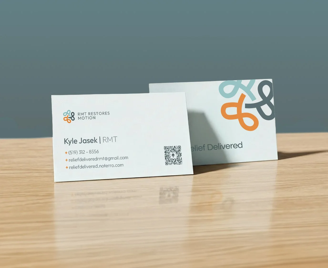 Relief Delivered business cards for Kyle Jasek, RMT, with a looping teal, orange and slate mark